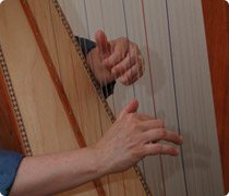 Hands playing a harp