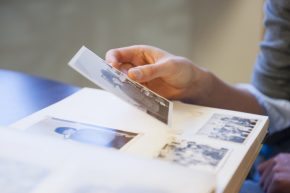 Close-up of a person looking through photos in a photo album