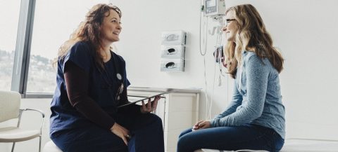 A nurse sits with a patient and has a dicsussion