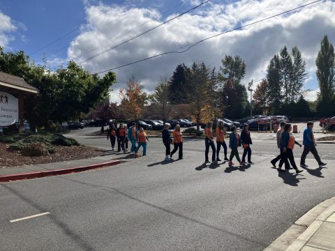 Orange T-shirt group walking across street