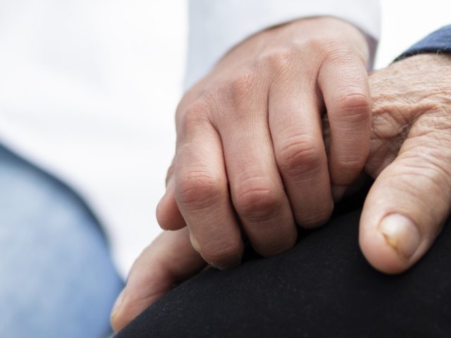 Two people clasp hands
