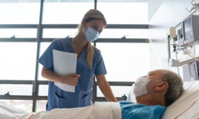 A nurse provides care to patient in a hospital bed