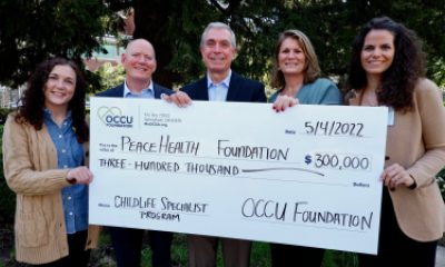 The OCCU Foundation presents PeaceHealth with a large check for the Childlife Specialist Program