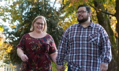 Ray and Jillian walking in a park-like setting with trees in the background
