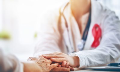 Care provider reaches for hands of woman to provide comfort