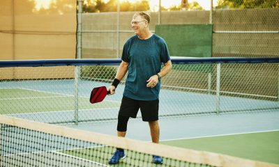 Older man playing pickleball. 