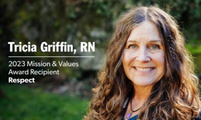 Tricia Griffin outside in front of green trees and grass