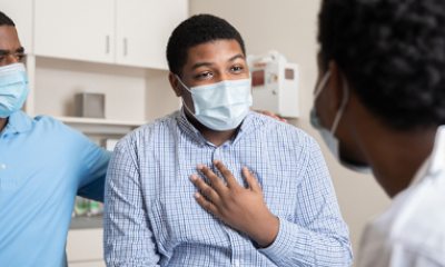 Adult parent and teen patient speak with a physician in an exam room