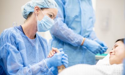 Nurse holds hand of surgery patient