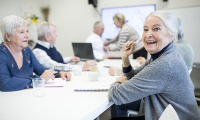 Seniors sitting around a table smiling and talking