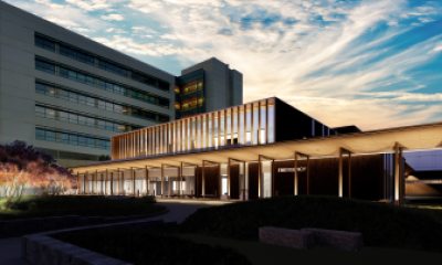 PeaceHealth Southwest Medical Center's new Emergency Department at sunset. The two-story building is illuminated with lights and the sky is blue, streaked with white clouds.