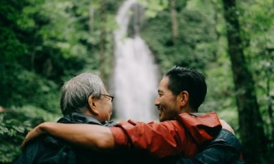 Father and son on bench in conversation in front of a waterfall