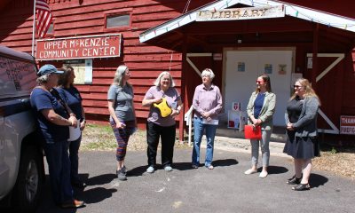 People stand in front of the Upper McKenzie Community Center during a ceremony to donate an automated defibrillator device.