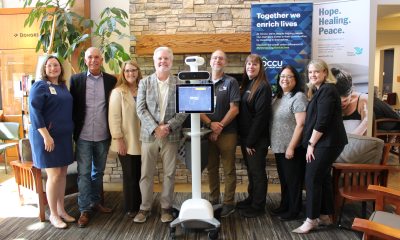 Members of the OCCU Foundation and PeaceHealth Foundation stand aside a computer-like device used by doctors who are offsite to communicate and examine patients.