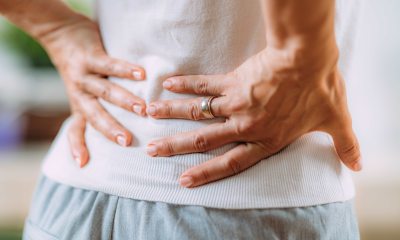 Close-up of hands of someone holding lower back