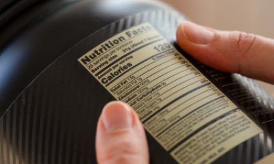 close-up of hands holding jar to examine nutrition label