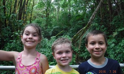 Three kids outdoors smiling for the camera