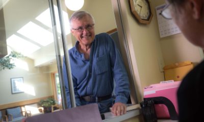 An elderly man checks in for a patient appointment