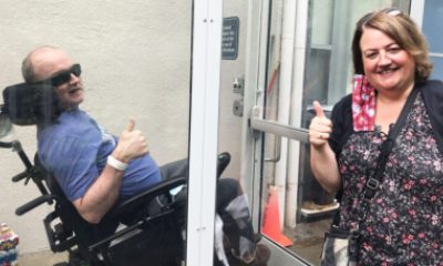 Sister visits brother in long-term-care facility behind glass