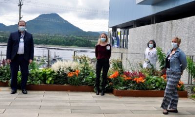 A group of masked caregivers stand 6 feet apart and pose 