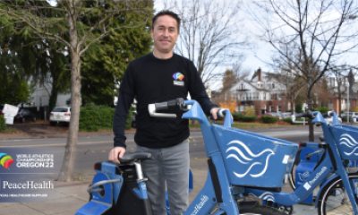 Dr. Hans Notenboom standing next to a bicycke with the PeaceHealth logo