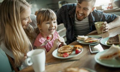 A family sits at the food table, enjoying breakfast and laughing