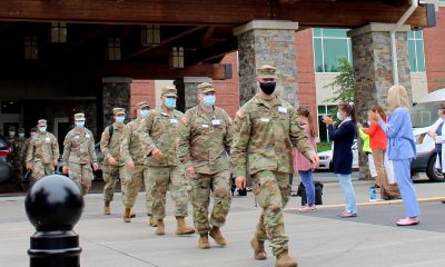 A group of PeaceHealth staff claps for National Guard members as they exit the hospital. 
