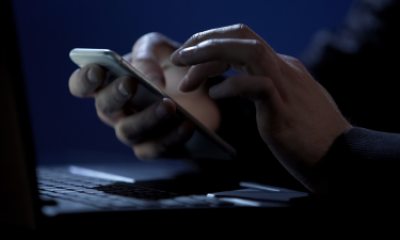 close up of hands holding cell phone in a dark room