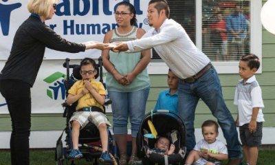 Carol Aaron presents a document to a family at a Habitat for Humanity event
