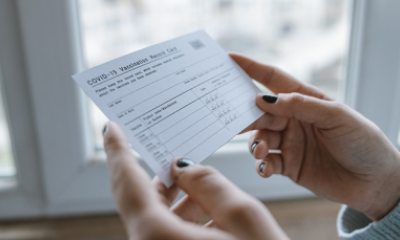 Hands of a young woman hold a COVID-19 vaccination card
