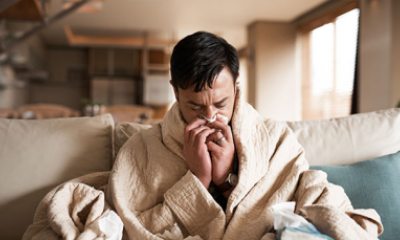 Person sneezes into tissue