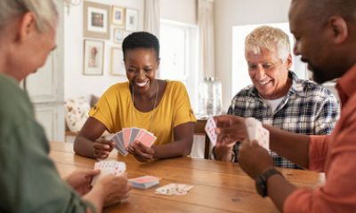 Four people happily playing a card game
