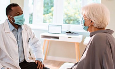 Doctor talks with a woman patient in exam room