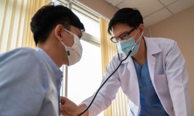 Doctor uses stethoscope to listen to heart of a patient
