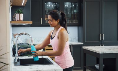 Woman filling water bottle.