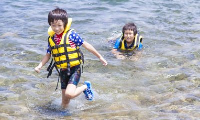 Two young boys swimming in a lake
