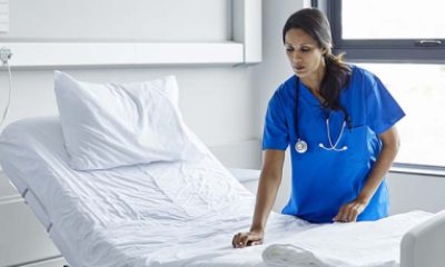 nursing assistant making a hospital bed