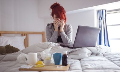 young woman blowing nose into a tissue
