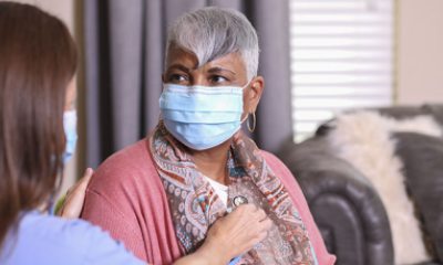 Healthcare worker listens to a woman's heart