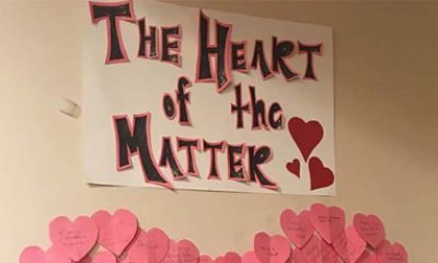 A sign hangs on the wall adorned with hearts and the phrase "The Heart of the Matter" written on it