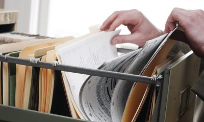 Hands going through documents in a filing cabinet