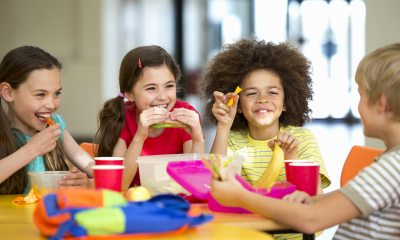 Group of toddlers eat lunch, smile and laugh