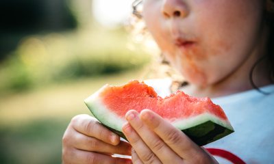 A young girl enjoys a slice of watermelon
