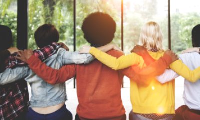 A group of people with their backs to the camera embracing