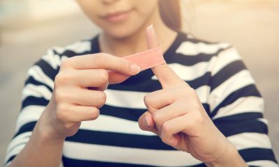 A woman puts a bandage on her left index finger