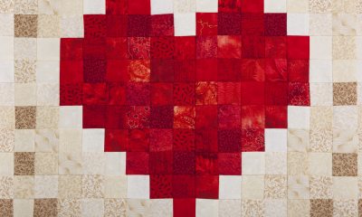 A quilt with an embroidered red heart