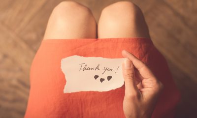 Close-up of Thank you note with drawn hearts, resting on a lap