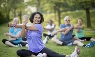 A group of seniors performing stretching exercises in the park