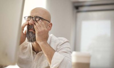 A man rubbing his eyes under his glasses