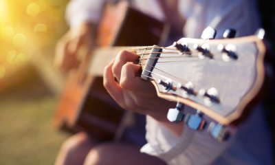A person playing a C chord on an acoustic guitar